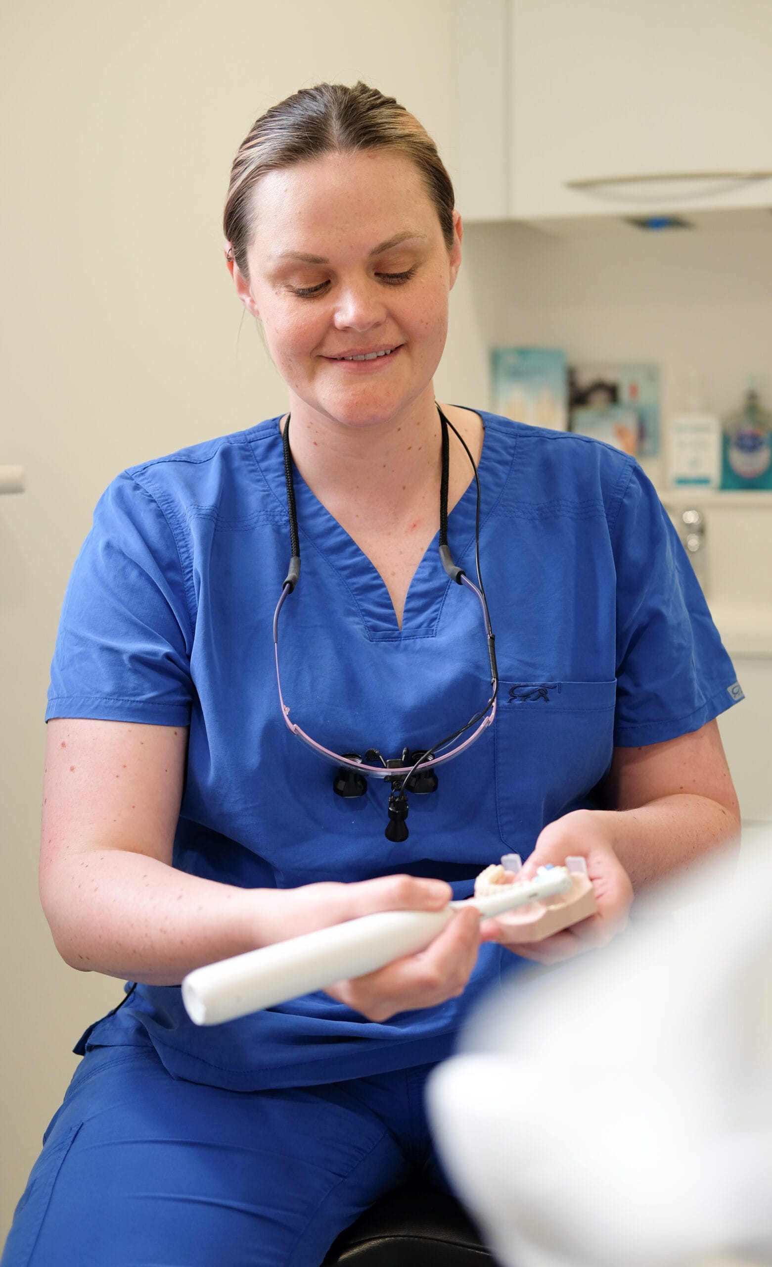 Hygienist demonstrating how to use an electric toothbrush